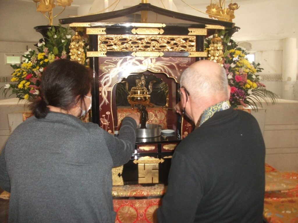 昨年の高塔山仏舎利塔での花まつり法要 
参詣者が、誕生仏に甘露に見立てた甘茶をかけています 